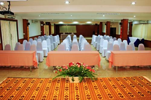 a banquet hall with orange tables and white chairs at Namkhong Riverside in Chiang Khong