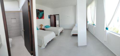 a hospital room with two beds and a mirror at Gallardos Suite in Puerto Ayora