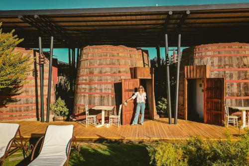a woman standing on a deck in front of a building at Cava Colchagua Hotel Boutique in Santa Cruz
