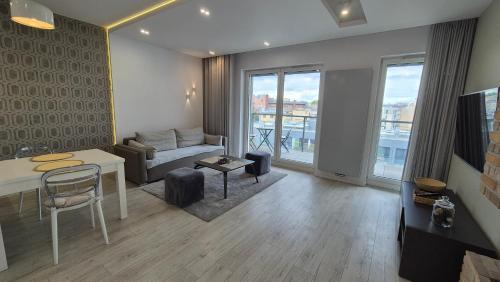 a living room with a couch and a table at Boznicza Old Town LUX Apartment, self check-in 24h, free parking in Poznań