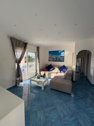 una sala de estar con un sofá y una mesa en Villetta Ischitana - Terrazza con Giardino, en Isquia