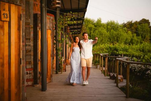 a man and a woman walking down a wooden walkway at Cava Colchagua Hotel Boutique in Santa Cruz