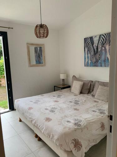 - une chambre avec un lit et une photo d'un zèbre dans l'établissement Mini Villa Santa Giulia à 120m de la plage, à Porto-Vecchio