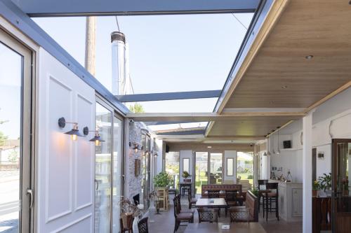 a conservatory with a glass ceiling and tables and chairs at Hotel Makedonia in Évzonoi