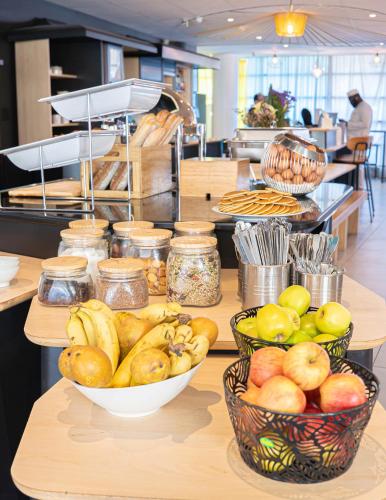 a counter with bowls of fruit on top at Novotel Suites Paris Montreuil Vincennes in Paris