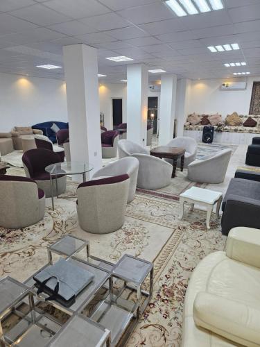 a waiting room with couches and tables and chairs at Al wafih in Al Khatim