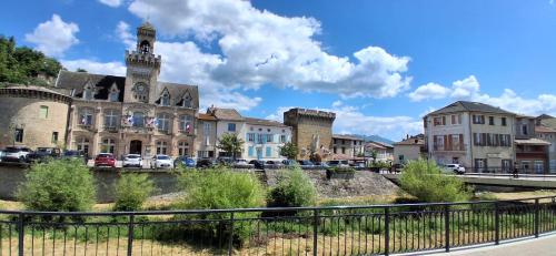 an old building with a clock tower in a town at Charmant studio Van Gogh in Chabeuil