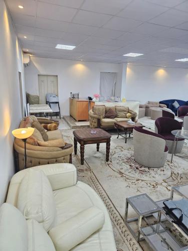 a living room filled with couches and tables at Al wafih in Al Khatim