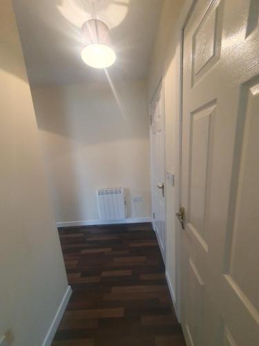 a hallway with a white door and a light at Pats Cottage in Donegal