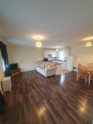 a large living room with a couch and a kitchen at Pats Cottage in Donegal