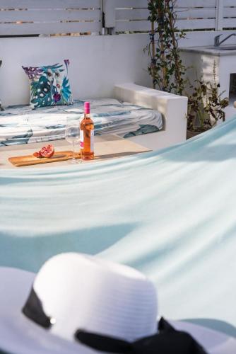 a bottle of oil and a hat on a bed at Villa Etoni, amazing sea views, infinity pool in Kalamitsi