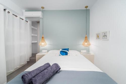 a bedroom with a bed with two purple towels on it at Villa Etoni, amazing sea views, infinity pool in Kalamitsi