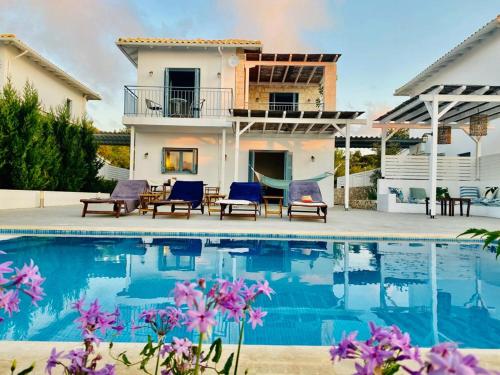 a villa with a swimming pool in front of a house at Villa Etoni, amazing sea views, infinity pool in Kalamitsi