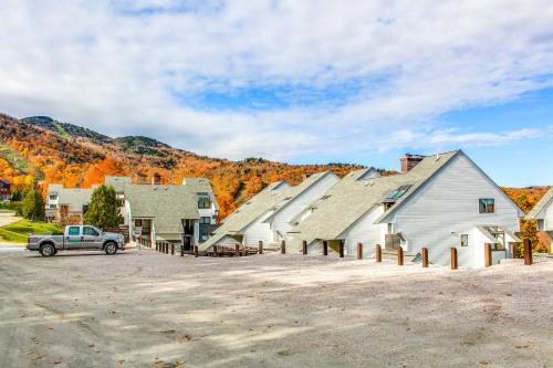 a group of buildings with a car parked in a parking lot at Sunrise - Timberline-L5 in Killington