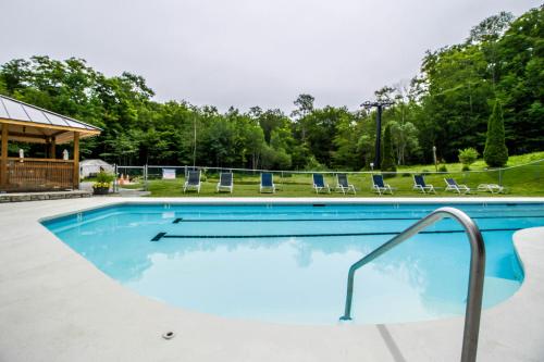 a swimming pool with blue chairs at Sunrise - Timberline-L5 in Killington