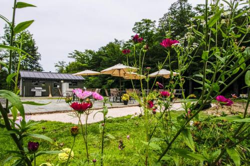 a garden with pink flowers and tables and umbrellas at Sunrise - Timberline-L5 in Killington