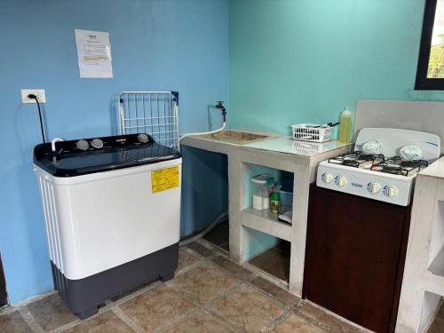 a small kitchen with a stove and a sink at Pura Vida Aparment - Downtown La Fortuna in Fortuna