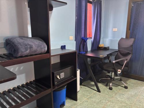 a dorm room with a desk and a bed and a chair at Pura Vida Aparment - Downtown La Fortuna in Fortuna