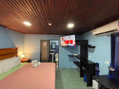 a bedroom with a bed and a tv on the wall at Pura Vida Aparment - Downtown La Fortuna in Fortuna