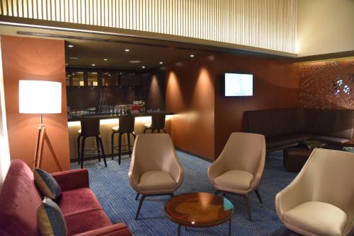 a living room with a couch and a bar at Grand Mercure Mysore - An Accor Brand in Mysore