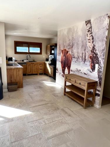 une cuisine avec un tableau de vaches sur le mur dans l'établissement Le chalet des monts, à Formiguères