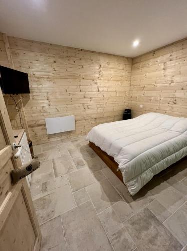 une chambre avec un lit et un sol carrelé dans l'établissement Le chalet des monts, à Formiguères