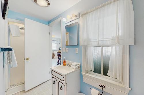 a bathroom with a white sink and a window at Cottage on the Cove in Wells