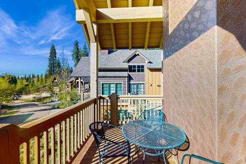 a patio with a glass table and chairs on a balcony at Tamarack Townhouse in Donnelly