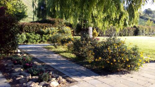 a walkway in a garden with flowers and a tree at Bigotti in Fano