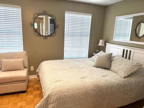 a bedroom with a bed and a mirror and a chair at Coastal Townhome in Jupiter 1 mile to beach! in Jupiter