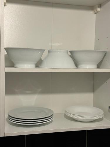 three plates and bowls on a shelf in a kitchen at Townhouse 4 bedrooms 4 double beds in Anzin