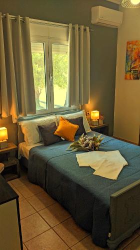 a bedroom with a bed with blue sheets and a window at Summer House Rocinante 1 in Vromerí