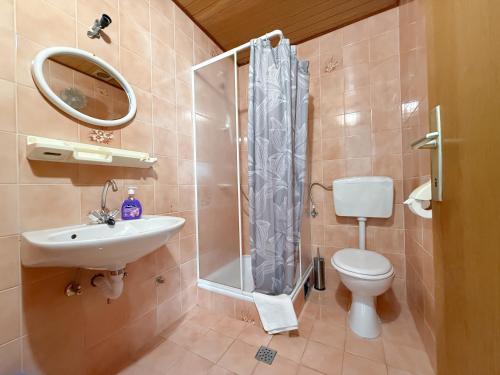 a bathroom with a toilet and a sink and a shower at House Ursić in Brela