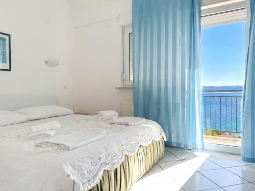 a bedroom with a bed and a large window at House Ursić in Brela