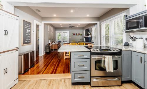 a kitchen with stainless steel appliances and wooden floors at C'est La Vie - make memories at our cozy bungalow in St Petersburg