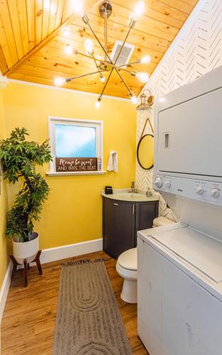 a bathroom with yellow walls and a sink and a toilet at C'est La Vie - make memories at our cozy bungalow in St. Petersburg