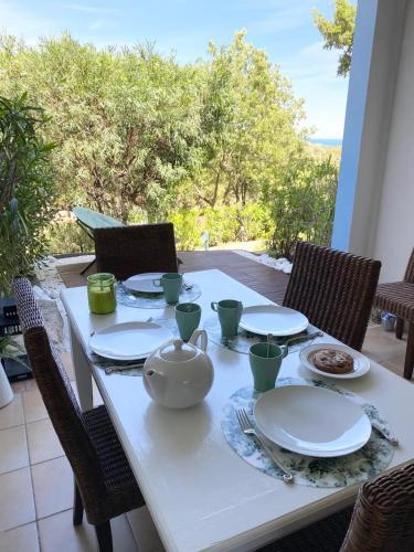 une table avec des assiettes et une théière dessus dans l'établissement Appartement T2 dans résidence Les Restanques du Golfe à Grimaud, à Grimaud