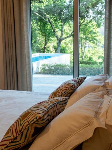 a bed with pillows in a room with a window at Tapada do Sobral in Vilar de Ferreiros