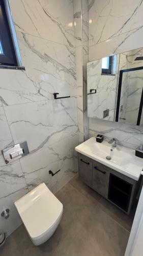 a white bathroom with a toilet and a sink at Villa Mia - 4 km to the sea 9 km to the airport in YeÅŸilkÃ¶y