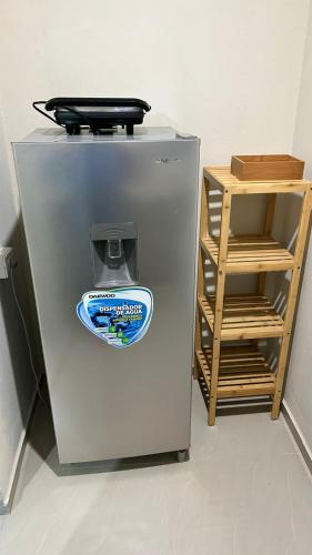 a refrigerator with a sticker on it next to a shelf at Cozy and Central Room in Mérida