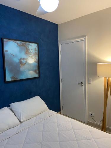 a bedroom with a bed and a blue wall at Makai Hotel Boutique - Frente Mar in Guarujá