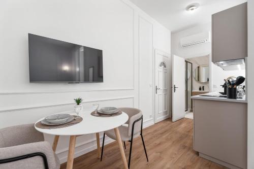 un salon avec une table et des chaises et une cuisine dans l'établissement Studio Bella - Welkeys, à Cannes