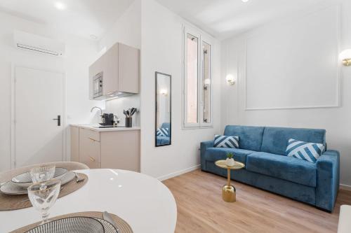 un salon avec un canapé bleu et une table dans l'établissement Studio Bella - Welkeys, à Cannes