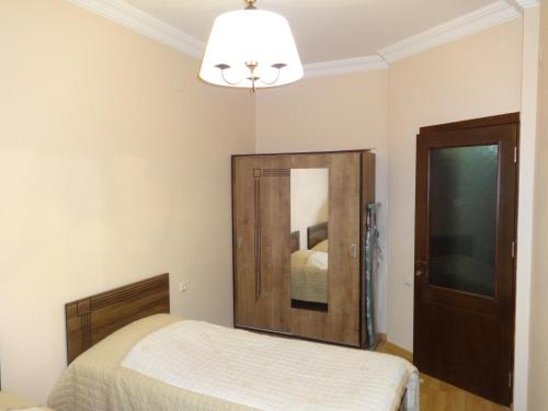 um quarto com uma cama e um espelho em Buoy Rooms em Batumi