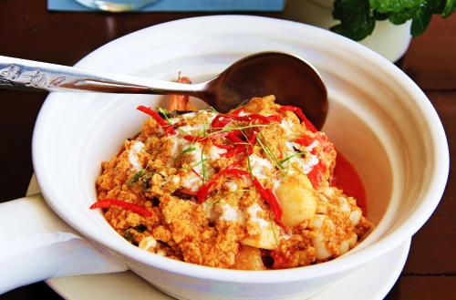 a bowl of food with a spoon on a table at Namkhong Riverside in Chiang Khong