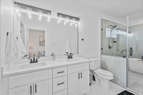 Un baño blanco con lavabo e inodoro. en High Style in H-Town with Luxury near Downtown, en Houston