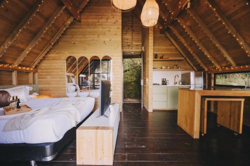 a bedroom with two beds and a kitchen in a cabin at KABINE in El Peñol