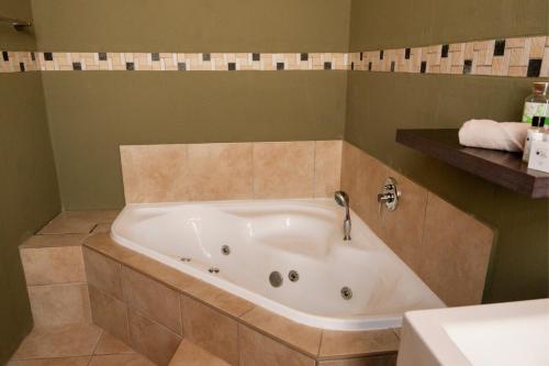 eine Badewanne in einem Badezimmer mit Waschbecken in der Unterkunft Fourteen Tumbleweed, Cathkin Estates by Euphoric Leisure in Ardmore