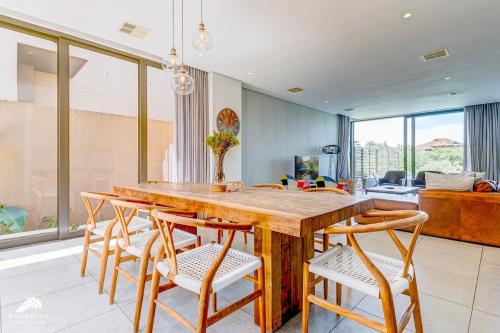 ein Esszimmer mit einem Holztisch und Stühlen in der Unterkunft Oceans Edge 4, Zimbali Estate by Euphoric Leisure in Ballito