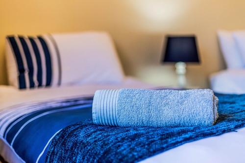 a blue towel laying on top of a bed at Serenity, Cathkin Estates by Euphoric Leisure in Winterton